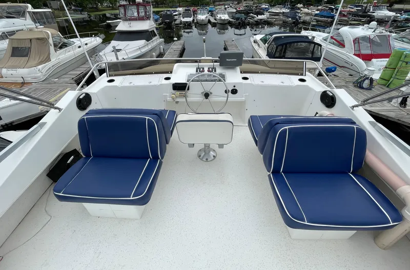 Slide: The Image of Cockpit of a 2003 Gibson 50 Classic boat with blue cushioned seats. - 14