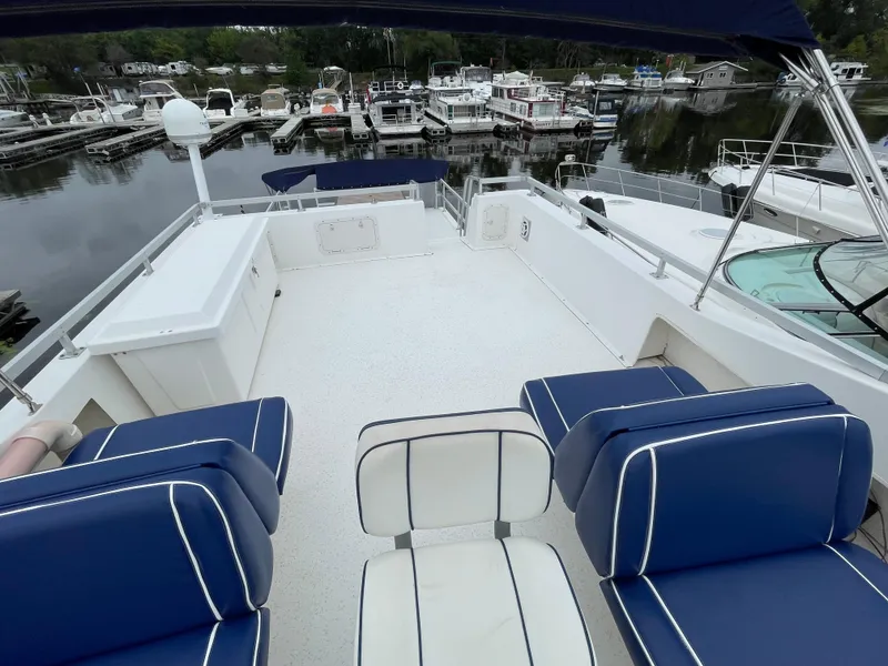 Slide: The Image of 2003 Gibson 50 Classic boat deck with blue seating, docked at a marina. - 15