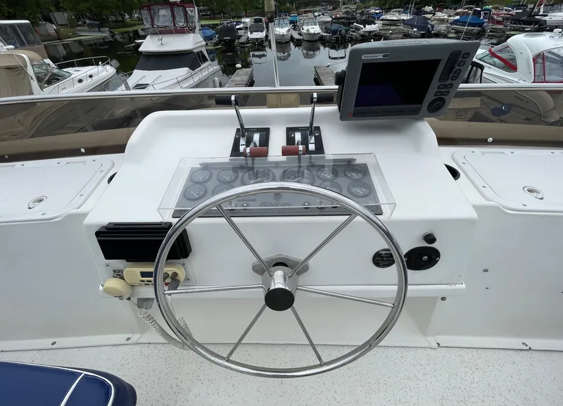 Slide: The Image of Helm of a 2003 Gibson 50 Classic boat with steering wheel and navigation equipment. - 16