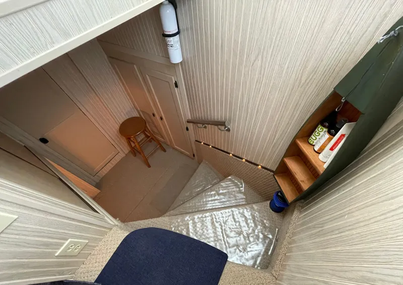 Slide: The Image of Staircase with beige walls, wooden shelves, and a stool at the bottom. - 39