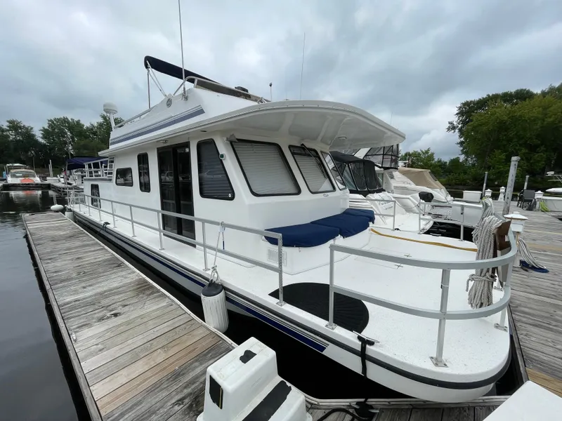 Slide: The Image of 2003 Gibson 50 Classic boat docked at marina under cloudy sky. - 4