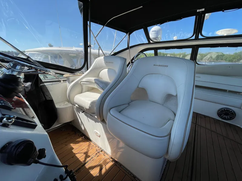 Slide: The Image of 2008 Silverton Sport Bridge interior with white captain's chairs and wooden flooring. - 21