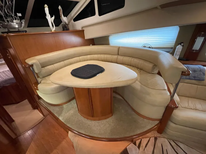 Slide: The Image of 2008 Silverton Sport Bridge interior with curved seating and table, featuring elegant wood accents. - 38