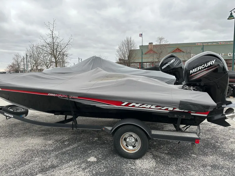 Slide: The Image of 2017 Tracker Pro Team 195 TXW boat with cover and Mercury engine, parked outdoors. - 7