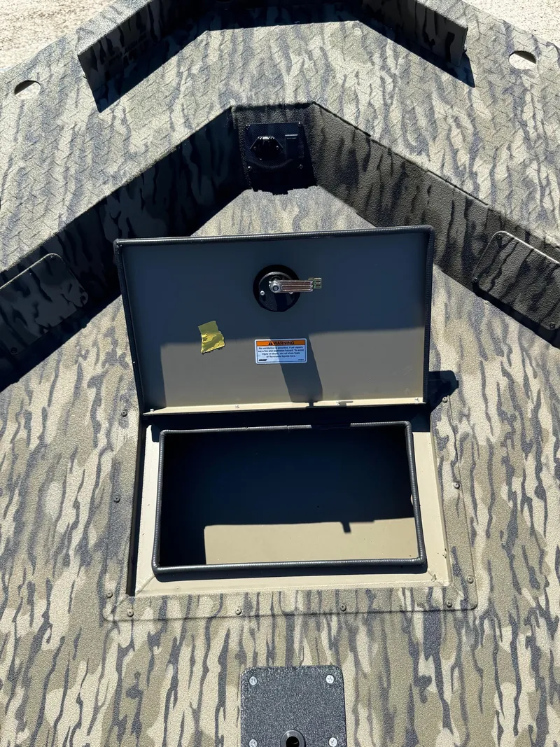 Slide: The Image of 2025 SeaArk 1648 Slayer Pro boat with open storage compartment, camo pattern. - 17