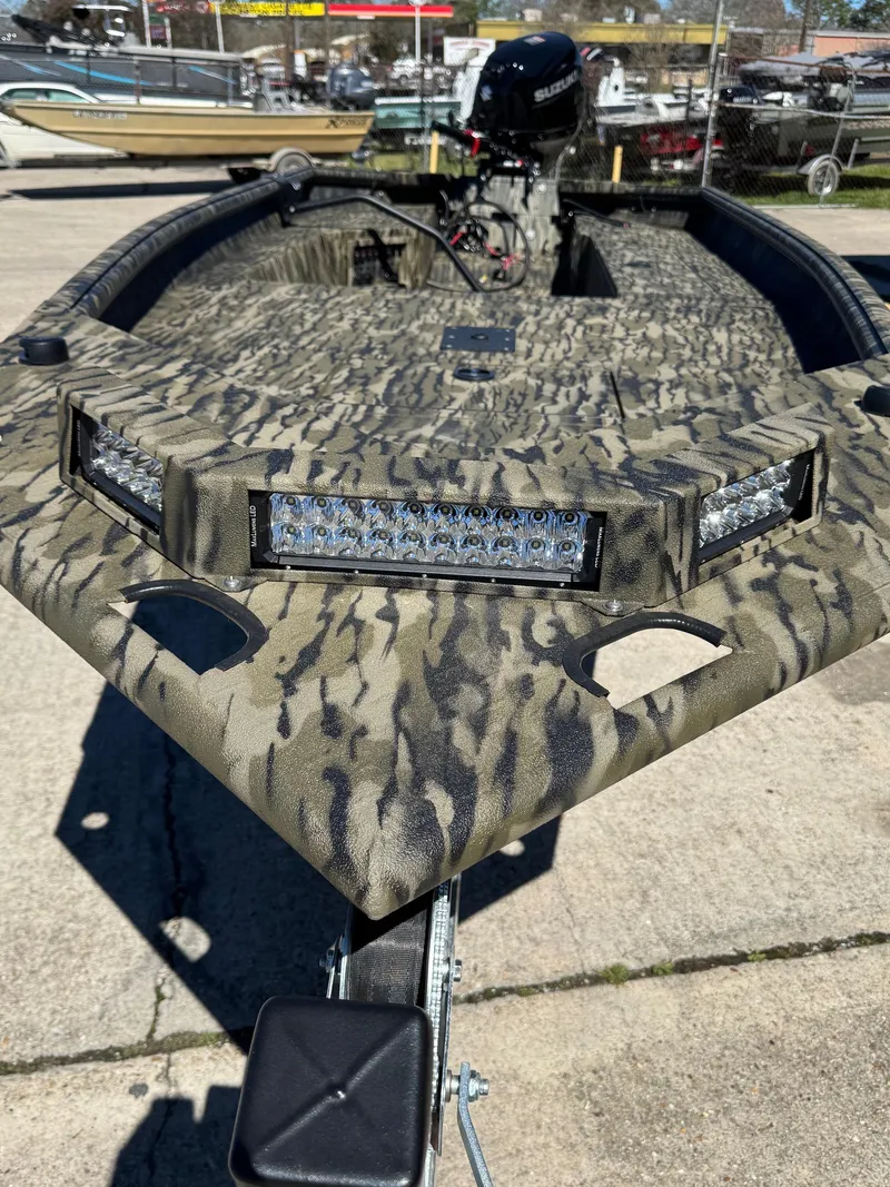Slide: The Image of 2025 SeaArk 1648 Slayer Pro boat with camouflage design and LED lights. - 4