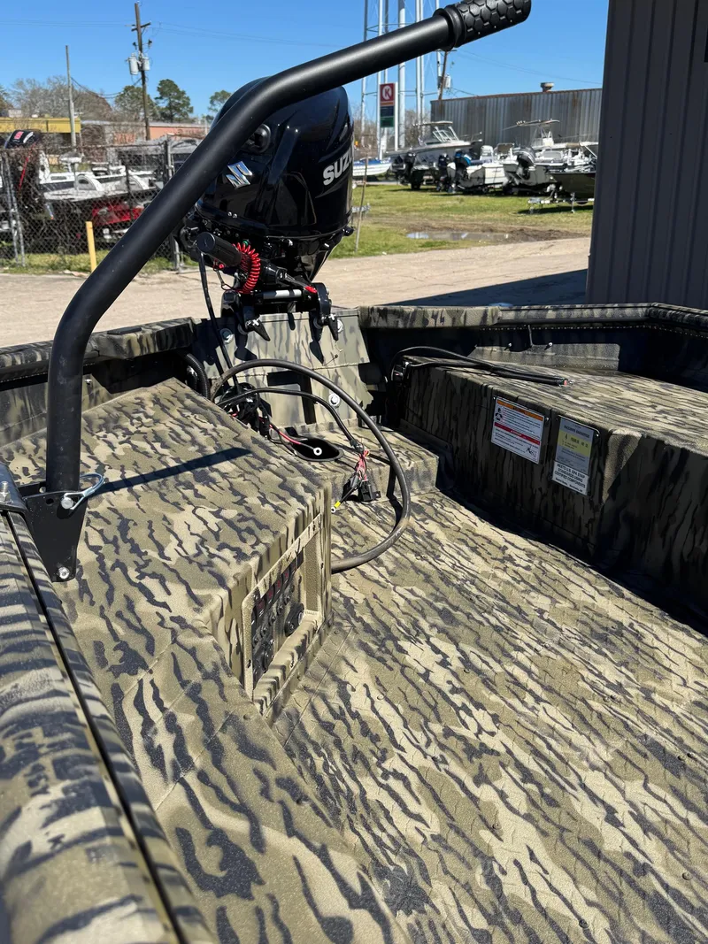 Slide: The Image of 2025 SeaArk 1648 Slayer Pro boat interior with camouflage design and Suzuki motor. - 8