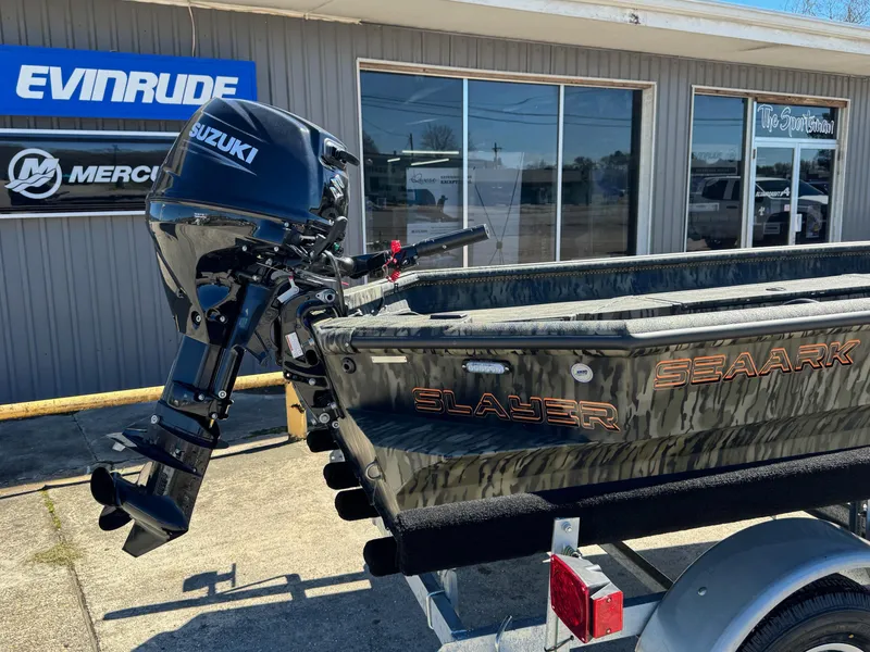 Slide: The Image of 2025 SeaArk 1648 Slayer Pro boat with Suzuki outboard motor, parked outside dealership. - 9