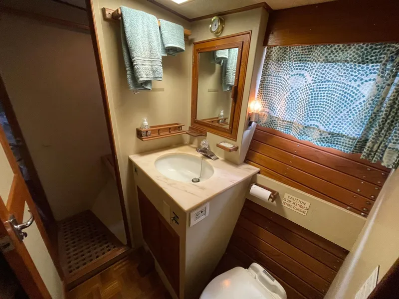 Slide: The Image of 1972 Grand Banks Alaskan 55 yacht bathroom with sink, mirror, and wooden accents. - 16