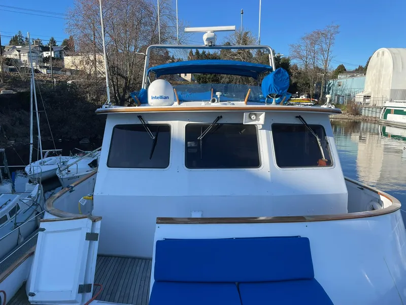 Slide: The Image of 1972 Grand Banks Alaskan 55 yacht docked, featuring blue seating and navigation equipment. - 3