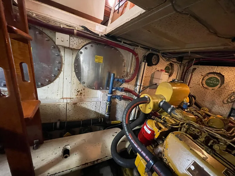 Slide: The Image of Engine room of a 1972 Grand Banks Alaskan 55 yacht, featuring machinery and piping. - 38
