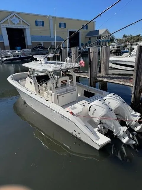 Slide: The Image of 2025 Pursuit S 328 Sport boat docked at a marina with twin engines. - 13