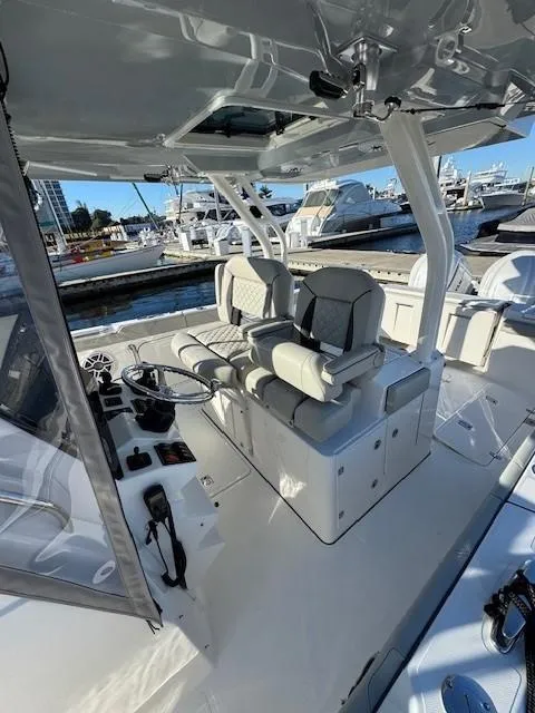 Slide: The Image of 2025 Pursuit S 328 Sport boat interior with dual seats and control panel at marina. - 3