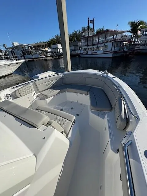 Slide: The Image of 2025 Pursuit S 328 Sport boat docked in a marina, showcasing spacious seating and sleek design. - 6