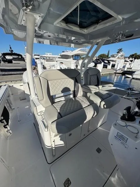 Slide: The Image of 2025 Pursuit S 328 Sport boat interior with luxurious seating at a marina. - 7