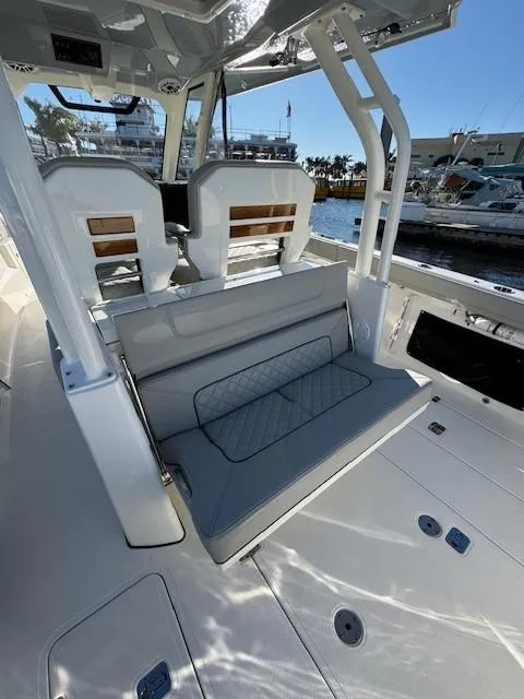 Slide: The Image of 2025 Pursuit S 328 Sport boat interior with seating and helm, docked at marina. - 9