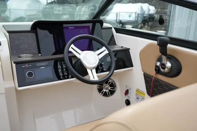 Slide: The Image of 2021 Sea Ray SDX 250 helm with steering wheel and control panel. - 13