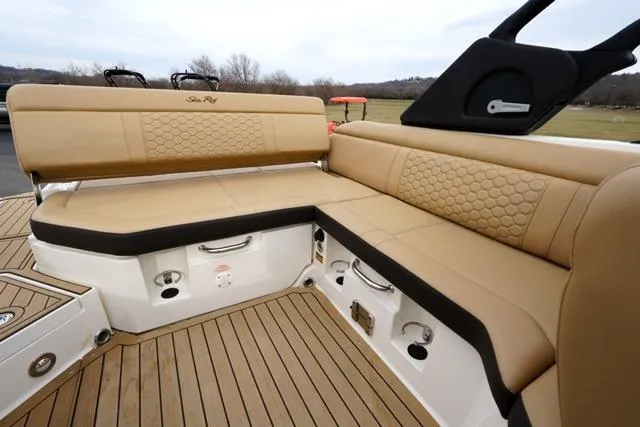 Slide: The Image of 2021 Sea Ray SDX 250 boat interior with tan seating and wood flooring. - 16