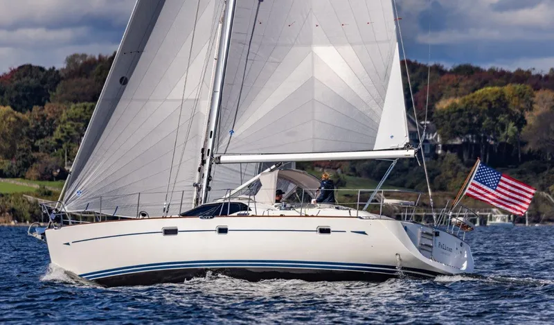 Slide: The Image of Sailing yacht Oyster 46, 2008 model, cruising on a scenic waterway with American flag. - 0