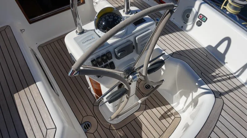 Slide: The Image of Steering wheel and controls of a 2008 Oyster 46 yacht, featuring teak decking. - 14