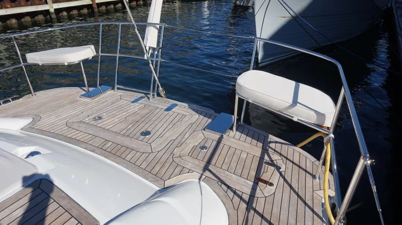 Slide: The Image of Teak deck of 2008 Oyster 46 yacht with seating, docked by the water. - 29