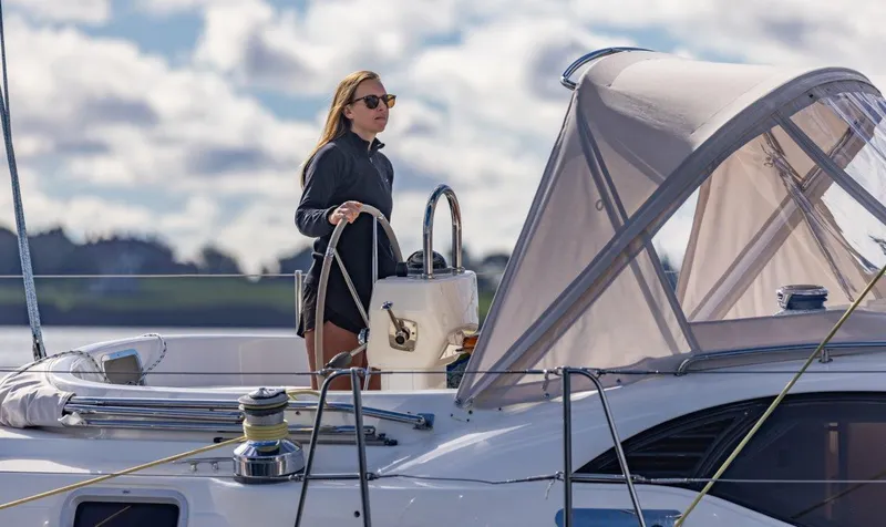 Slide: The Image of Woman steering 2008 Oyster 46 yacht under cloudy sky. - 3