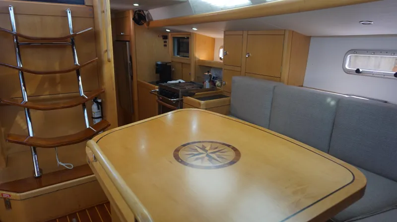 Slide: The Image of Interior of 2008 Oyster 46 yacht with wooden table and seating area. - 35