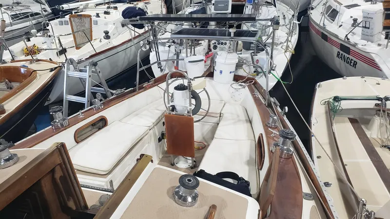 Slide: The Image of 1981 Shannon 28 sailboat with wooden deck, docked among other boats in a marina. - 13