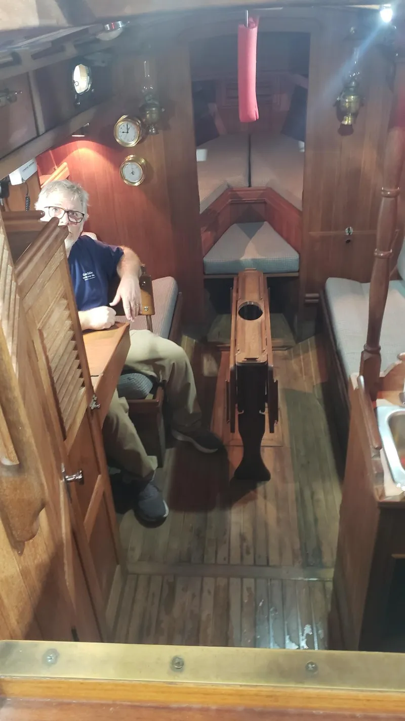 Slide: The Image of Interior of a 1981 Shannon 28 sailboat with wooden furnishings and cozy seating. - 15