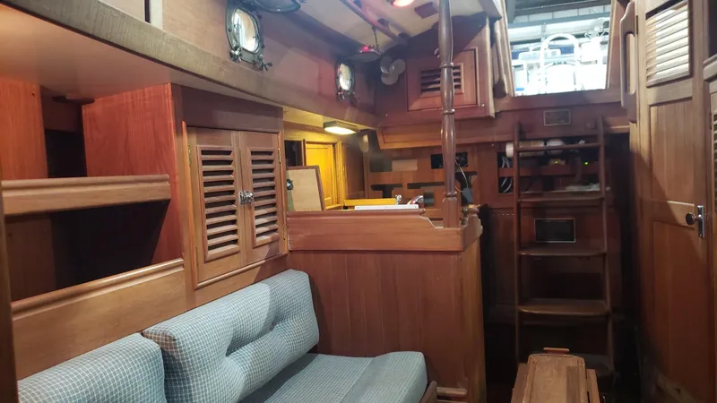 Slide: The Image of Interior of a 1981 Shannon 28 sailboat, featuring wooden cabinetry and a cushioned seating area. - 19