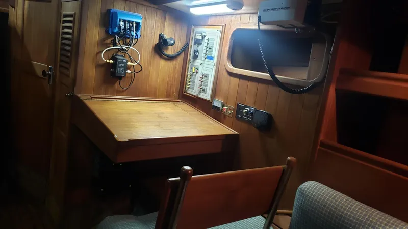 Slide: The Image of 1981 Shannon 28 sailboat interior with navigation station, wooden desk, and electrical panel. - 20