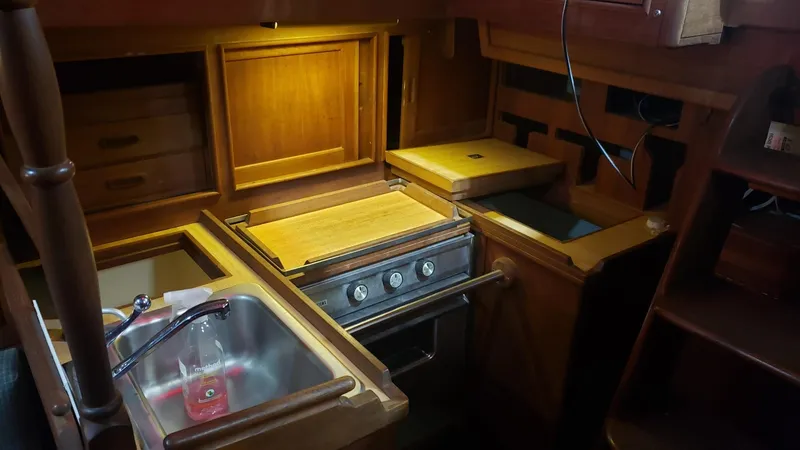 Slide: The Image of 1981 Shannon 28 yacht interior kitchen with wooden cabinetry, stove, and sink. - 24