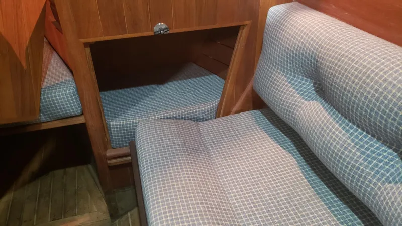 Slide: The Image of Interior of 1981 Shannon 28 sailboat with blue checkered upholstery and wooden paneling. - 29