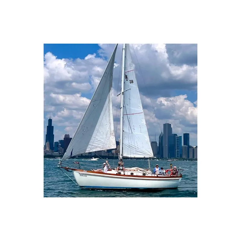 Slide: The Image of Sailboat Shannon 28 (1981) cruising near city skyline under cloudy sky. - 3