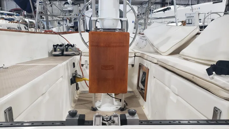 Slide: The Image of 1981 Shannon 28 sailboat cockpit with wooden panel and seating, showcasing nautical equipment. - 33