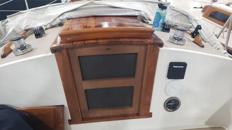 Slide: The Image of 1981 Shannon 28 sailboat cockpit with wooden hatch, winches, and navigation equipment. - 34