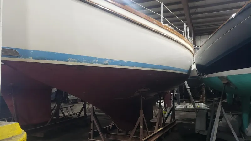 Slide: The Image of 1981 Shannon 28 sailboat in storage, showing hull and keel in a boatyard. - 8