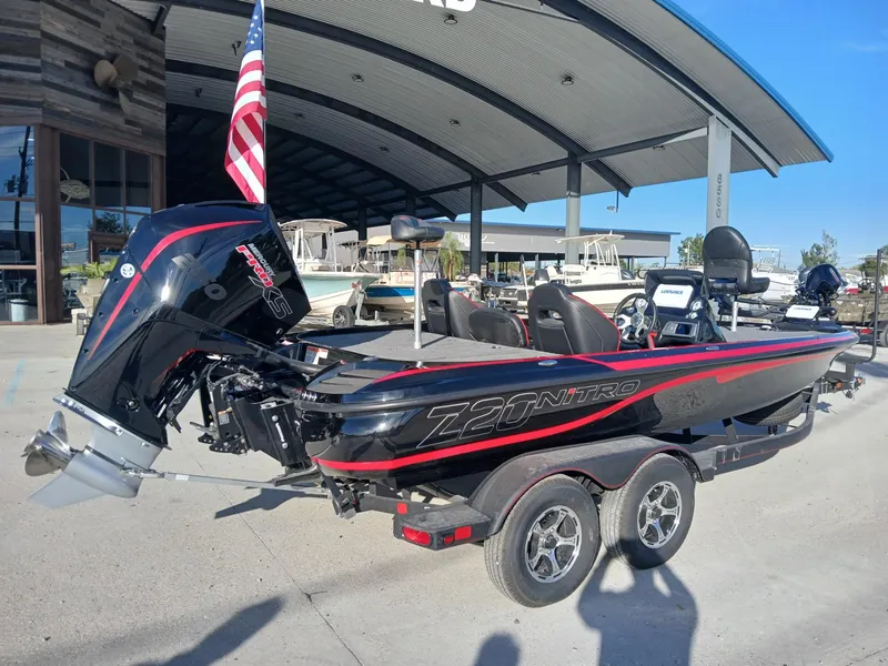 Slide: The Image of 2024 Nitro Z20 boat with trailer, parked outdoors, featuring sleek design and American flag. - 10