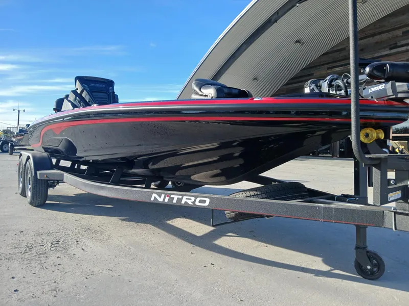 Slide: The Image of 2024 Nitro Z20 boat on trailer, sleek black and red design, parked outdoors. - 13