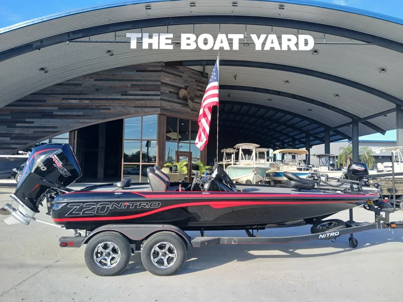 Slide: The Image of 2024 Nitro Z20 boat displayed at The Boat Yard with American flag. - 2