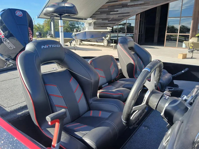 Slide: The Image of 2024 Nitro Z20 boat interior with sleek black and red seats, steering wheel, and controls. - 5