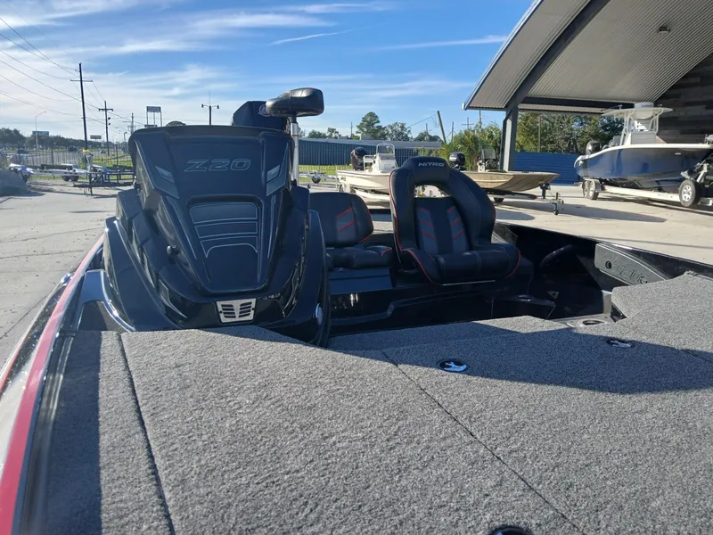 Slide: The Image of 2024 Nitro Z20 boat with dual seats and motor, parked outdoors under clear skies. - 6