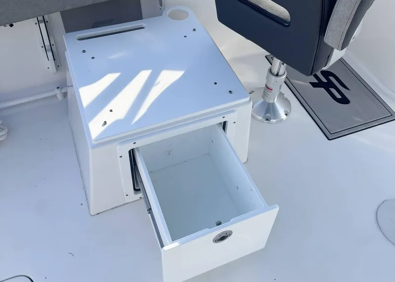 Slide: The Image of 2023 Sea Pro 240 DC boat interior with open storage drawer and seating. - 12