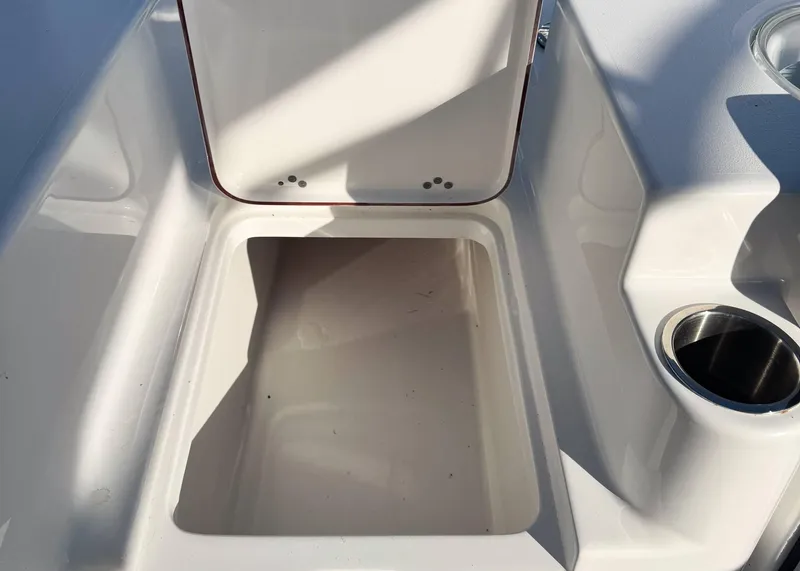 Slide: The Image of Open storage compartment on 2023 Sea Pro 240 DC boat with cup holder. - 9