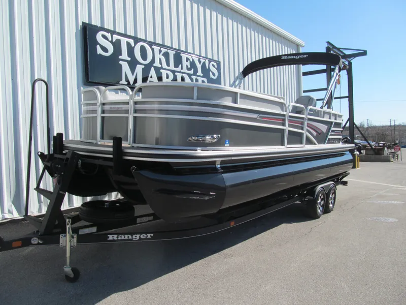 The Image of 2019 Ranger Reata 243C pontoon boat on trailer, parked outside marine store. - 0