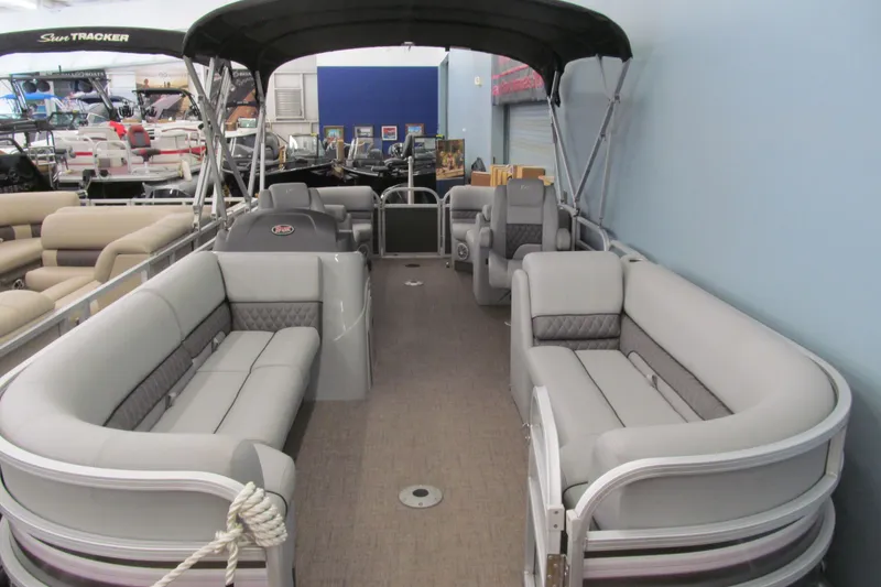 Slide: The Image of 2019 Ranger Reata 243C pontoon boat with spacious seating and canopy in showroom. - 16
