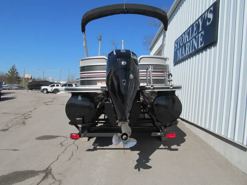 Slide: The Image of 2019 Ranger Reata 243C pontoon boat with Mercury engine, parked outside a dealership. - 3