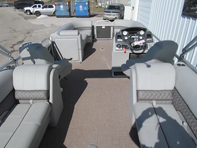 Slide: The Image of 2019 Ranger Reata 243C pontoon boat interior with plush seating and steering console. - 5