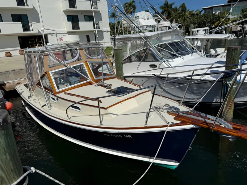 Slide: The Image of 1978 Dyer 29 Trunk Cabin interior with sink, wooden flooring, and cozy sleeping area. - 2