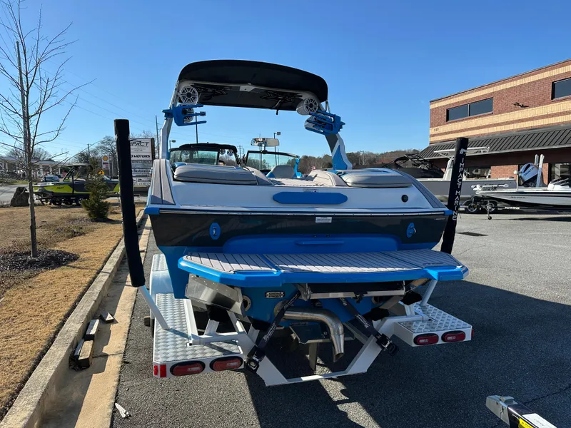 Slide: The Image of 2022 MB B52 23 Alpha boat, blue and white, parked outdoors on a sunny day. - 3